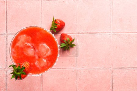 Photo for Strawberry margarita with tequila, ice, strawberry and lime at pink background. Flat lay image with copy space. - Royalty Free Image