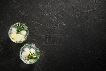 Téléchargez les photos : Gin tonique, cocktail traditionnel sur fond noir. Vue de dessus avec espace pour le design. - en image libre de droit
