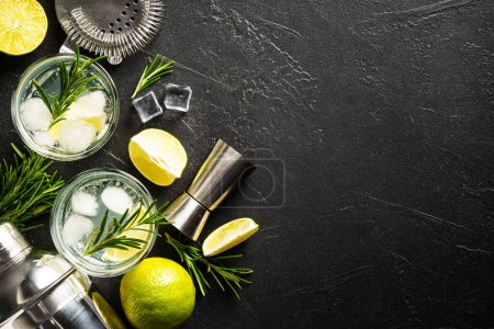 Téléchargez les photos : Gin tonique, cocktail traditionnel sur fond noir. Vue de dessus avec espace pour le design. - en image libre de droit