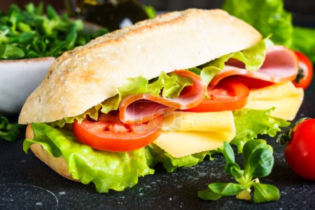 Téléchargez les photos : Sandwich à la laitue, fromage, tomates et jambon. Restauration rapide saine, petit déjeuner ou déjeuner. Gros plan. - en image libre de droit