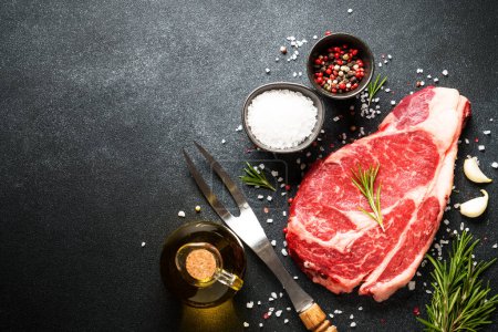 Photo for Raw meat steak with spices on black background. Beef steak ribeye. Top view with copy space. - Royalty Free Image
