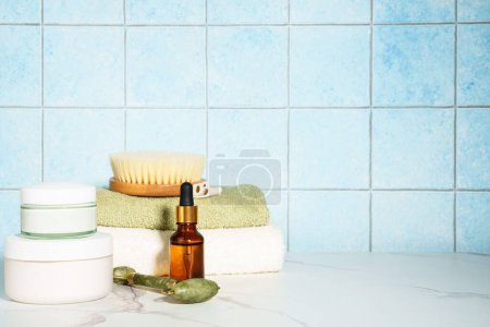 Photo for Spa treatment bakground. Face cream, serum bottle, shapmoo and stack of towels. - Royalty Free Image