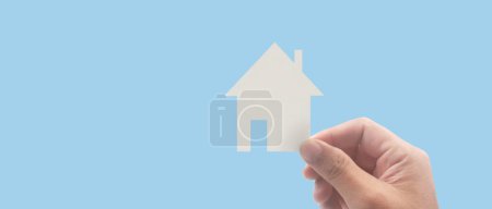 Téléchargez les photos : Mains tenant la maison en papier, la maison familiale et protégeant le concept d'assurance - en image libre de droit