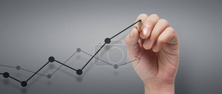 Photo for Male hand drawing graph chart showing business profit growth increasing to future - Royalty Free Image
