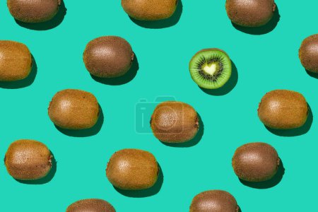 Photo for Graphic top view pattern of fresh kiwi fruit in diagonal lines on contrasted blue background, healthy eating and vegan concept, copy space - Royalty Free Image