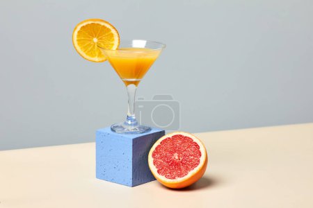 Photo for Minimal shot of fresh citrus juice in cocktail glass against pastel background with focus on grapefruit, dieting concept, copy space - Royalty Free Image