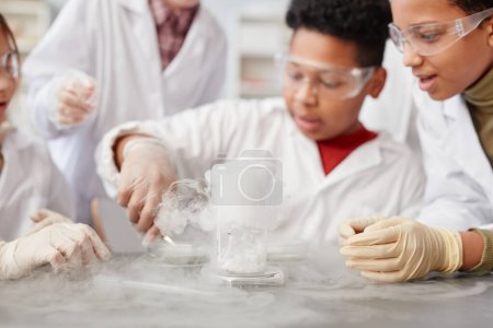 Téléchargez les photos : Gros plan du liquide moussant dans le verre de bécher sur la table dans le laboratoire de chimie de l'école, espace de copie - en image libre de droit