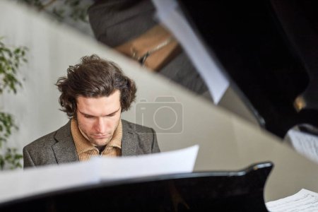 Téléchargez les photos : Jeune compositeur se concentrant sur sa pièce au piano à queue, il compose la nouvelle musique - en image libre de droit