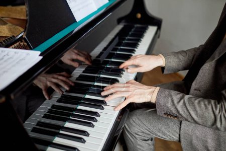 Téléchargez les photos : Gros plan du pianiste en costume jouant de la musique classique au piano lors d'une leçon de musique - en image libre de droit