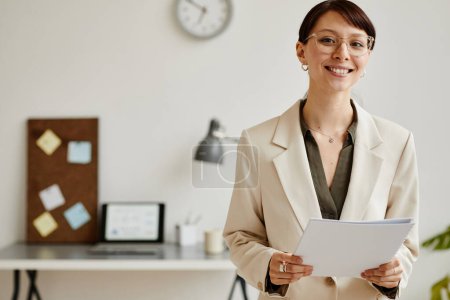 Photo for Minimal waist up portrait of elegant young woman smiling at camera while managing successful business from office, copy space - Royalty Free Image