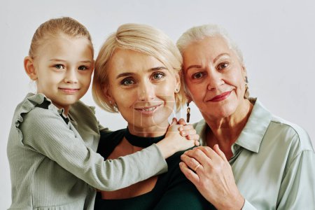 Téléchargez les photos : Minimal gros plan portrait de trois femmes en famille souriant à la caméra en studio - en image libre de droit