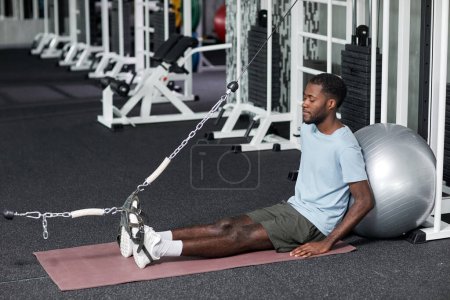 Téléchargez les photos : Portrait de jeune homme noir faisant des exercices de réadaptation en salle de gym à la clinique, espace de copie - en image libre de droit