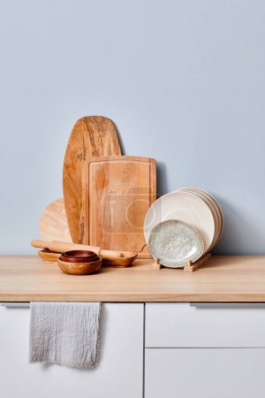 Foto de Imagen de tablas de cortar de madera de pie en una fila con placas en un soporte sobre la mesa - Imagen libre de derechos