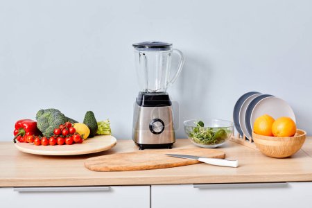 Téléchargez les photos : Fruits et légumes frais avec mélangeur automatique moderne sur la table pour faire du smoothie et du jus - en image libre de droit