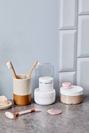 Foto de Mesa de baño en baño para mujer con cosméticos y mesoroller para el cuidado de la cara - Imagen libre de derechos