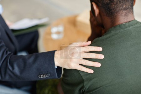 Téléchargez les photos : Psychologue professionnel méconnaissable réconfortant Soldat noir souffrant de dépression touchant son épaule - en image libre de droit