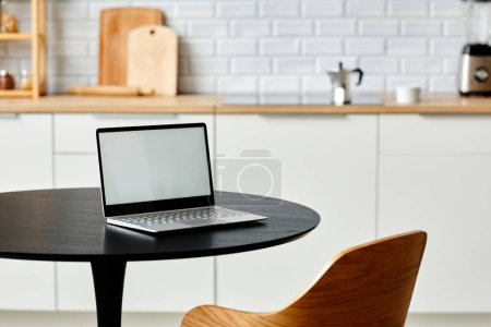 Foto de Mínimo lugar de trabajo de oficina en casa con portátil abierto en la mesa de cocina negro con una sola silla de madera, espacio de copia - Imagen libre de derechos