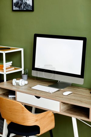 Téléchargez les photos : Image de fond verticale de l'écran d'ordinateur blanc au travail à la maison contre le mur vert, maquette - en image libre de droit