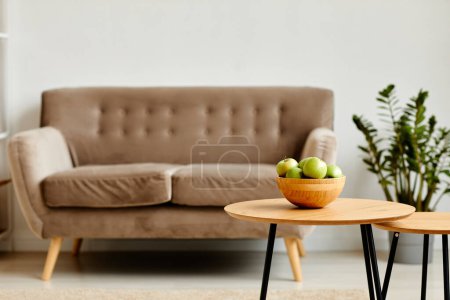 Foto de Imagen de fondo del tazón de manzanas verdes en la mesa de madera en el interior de la sala de estar mínima con sofá acogedor, espacio de copia - Imagen libre de derechos