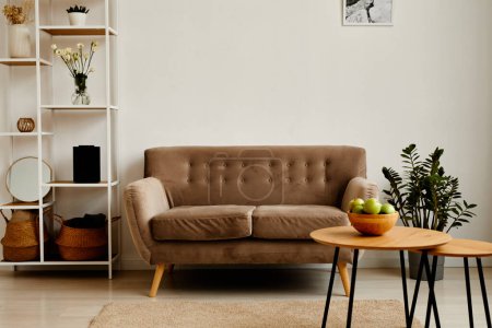 Téléchargez les photos : Image de fond du salon intérieur minimal avec canapé en velours et bol de pommes vertes sur une table en bois, espace de copie - en image libre de droit