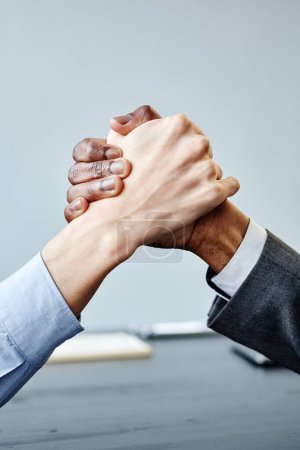 Foto de Primer plano vertical de dos socios comerciales estrechando la mano en la unidad en la mesa de reuniones, espacio para copiar - Imagen libre de derechos