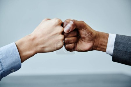 Photo for Close up of two business partners fistbumping in unity at meeting table, copy space - Royalty Free Image