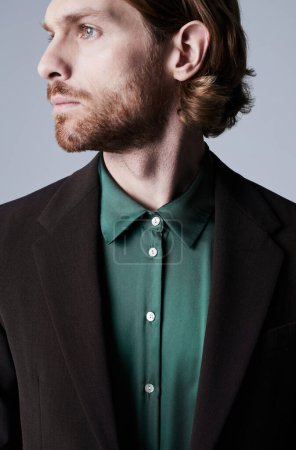 Photo for Minimal profile shot of handsome young man wearing trendy suit with teal green silk shirt - Royalty Free Image