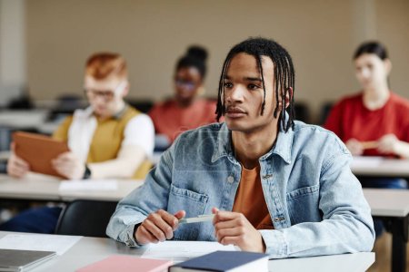 Photo for Portrait of black teenage boy with braids listening to lecture in school or college, copy space - Royalty Free Image