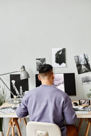 Foto de Vista posterior del creador masculino retocando fotografías en el lugar de trabajo de la oficina en casa y utilizando la computadora - Imagen libre de derechos