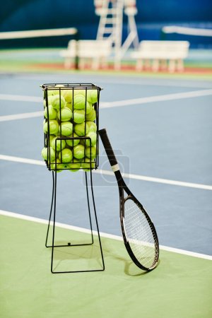 Téléchargez les photos : Image de fond verticale de raquette de tennis et panier à balles au court de tennis, espace de copie - en image libre de droit