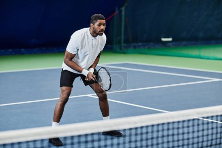 Téléchargez les photos : Portrait complet d'un sportif noir agile jouant au tennis à l'intérieur, espace de copie - en image libre de droit