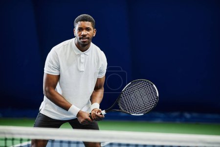 Téléchargez les photos : Portrait avant du beau sportif noir jouant au tennis à l'intérieur, espace de copie - en image libre de droit