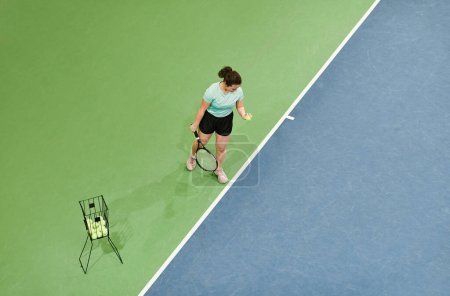 Téléchargez les photos : Vue de dessus minimale de la jeune femme jouant au tennis sur le terrain graphique, espace de copie - en image libre de droit