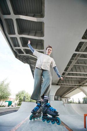 Téléchargez les photos : Vertical pleine longueur portrait de adolescent fille faire roller astuces dans skatepark à l'extérieur - en image libre de droit