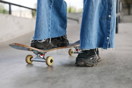 Photo for Closeup of teenager riding skateboard outdoors while wearing chunky shoes, copy space - Royalty Free Image
