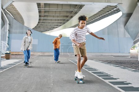 Foto de Retrato de larga duración del joven adolescente montando monopatín con amigos en el parque de skate al aire libre, espacio de copia - Imagen libre de derechos