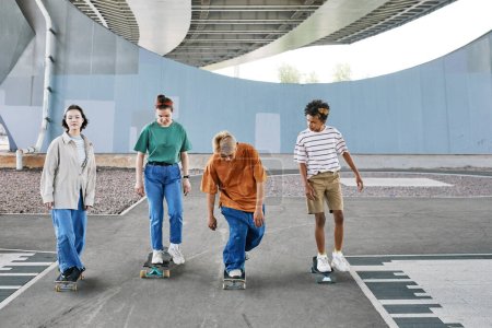 Photo for Full length shot of diverse group of teenagers riding skateboards in urban skating area, copy space - Royalty Free Image