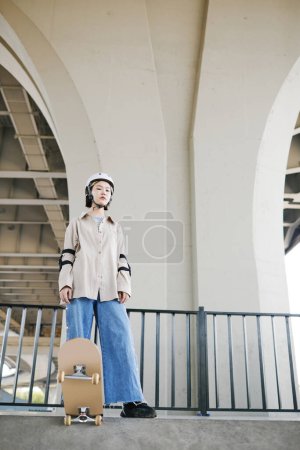 Téléchargez les photos : Portrait minime pleine longueur de la jeune fille portant des gardes de protection et un casque dans le parc de patinage à l'extérieur - en image libre de droit