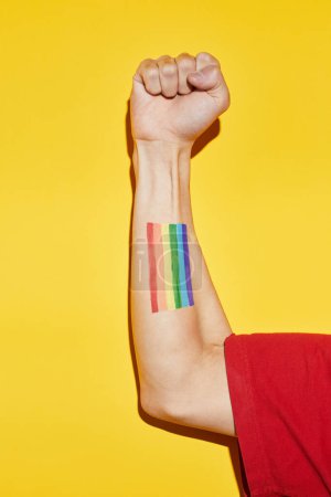 Téléchargez les photos : Vibrant coup de bras dans le poing avec tatouage drapeau arc-en-ciel comme symbole de pouvoir pour le mois de fierté LGBTQ - en image libre de droit