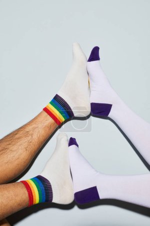 Téléchargez les photos : Plan minimal de jeune couple ludique portant des chaussettes pieds en l'air, espace de copie - en image libre de droit