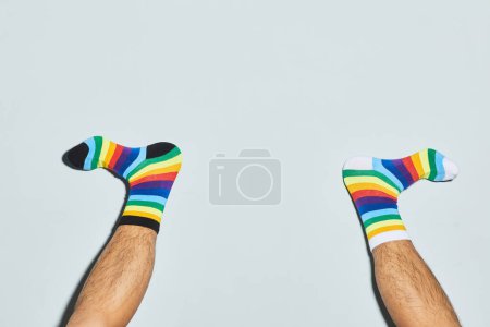 Foto de Mínimo tiro de hombre juguetón usando calcetines desiguales pies hacia arriba, espacio de copia - Imagen libre de derechos