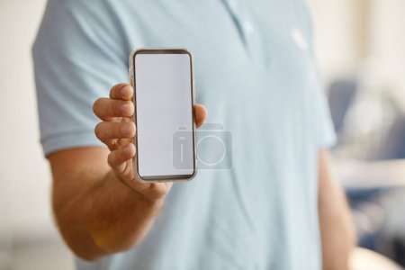 Photo for Minimal close up of unrecognizable man holding smartphone with blank screen to camera, copy space - Royalty Free Image