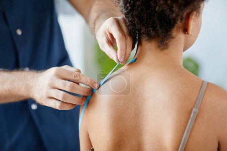 Photo for Close up rehabilitation therapist putting physio tape on shoulder of young woman to relieve muscle pain, copy space - Royalty Free Image