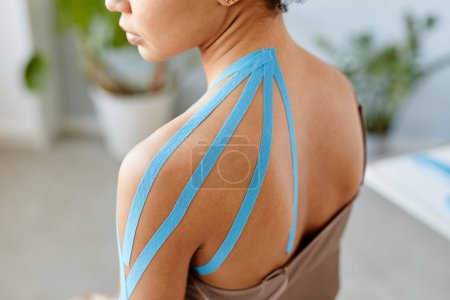 Photo for Close up of young black woman with physio tape on shoulder in rehabilitation therapy, copy space - Royalty Free Image