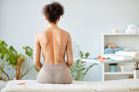 Photo for Minimal portrait of young woman with physio tape on nude back in rehabilitation clinic, copy space - Royalty Free Image