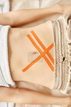 Photo for Top down view of young woman with physio tape on abdomen muscles, copy space - Royalty Free Image