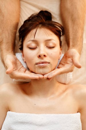 Photo for Top view at beautiful young woman enjoying face massage in SPA center with eyes closed - Royalty Free Image