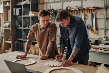 Téléchargez les photos : Portrait de deux artisan commerçants concevant des meubles en bois à l'intérieur de l'atelier - en image libre de droit
