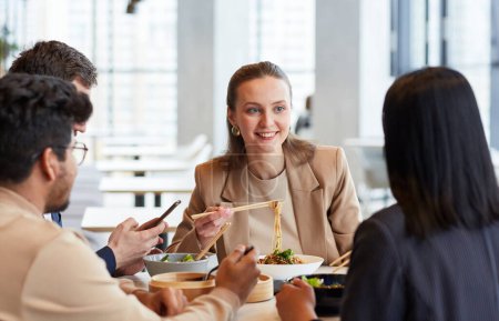 Téléchargez les photos : Portrait de femme d'affaires souriante profitant d'un déjeuner d'affaires avec des collègues dans un café alimentaire asiatique - en image libre de droit