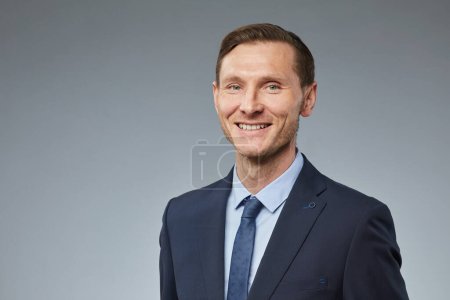 Foto de Retrato de hombre de negocios adulto sonriente mirando a la cámara sobre fondo gris liso, espacio de copia - Imagen libre de derechos